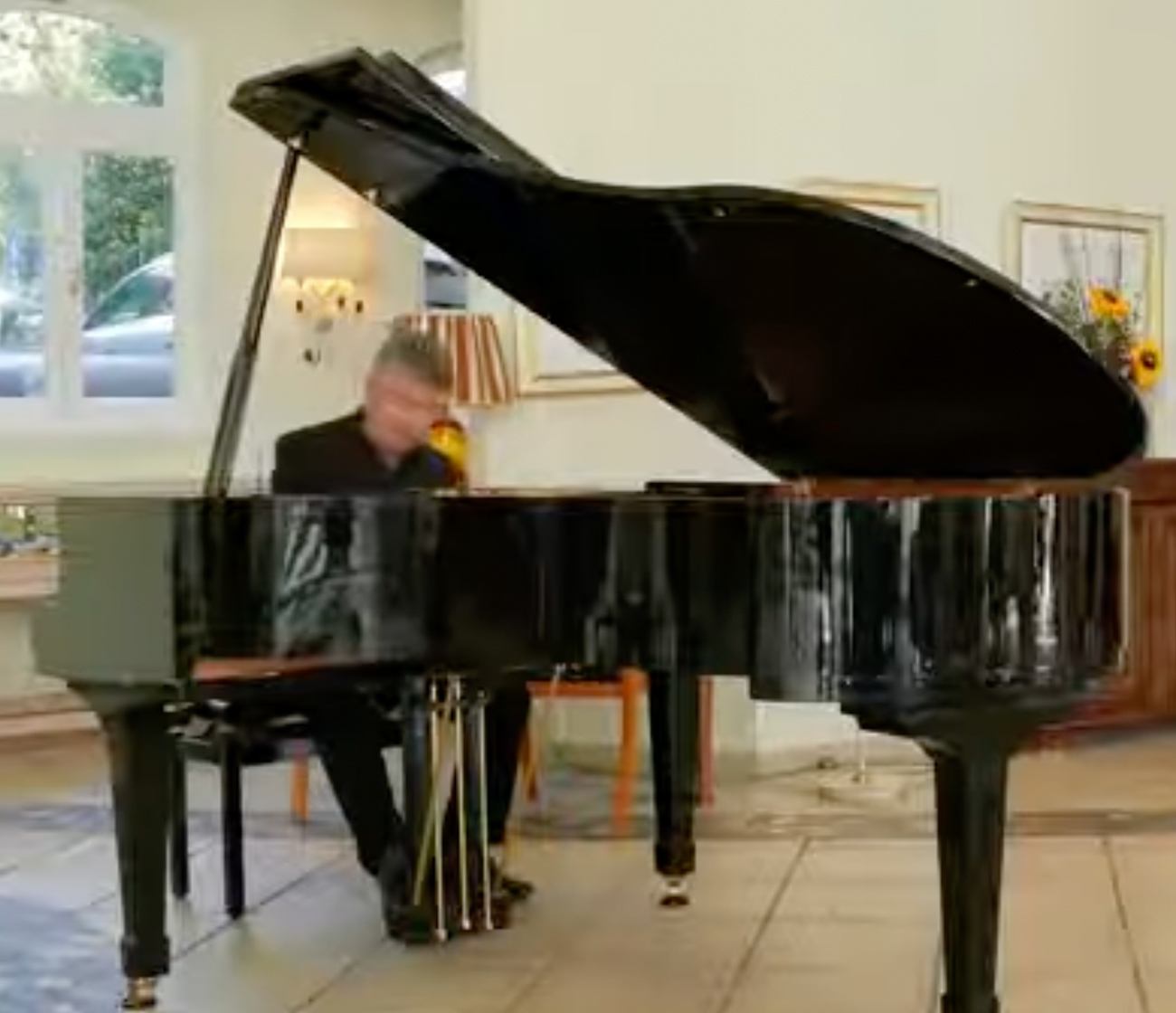 Dancer in light blue top leads energetic movement with two performers behind her in moody purple lighting.