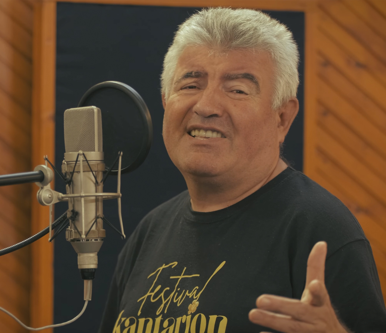 Ballet dancer in white tutu performs en pointe center stage with ensemble in blue lighting and stage lights.