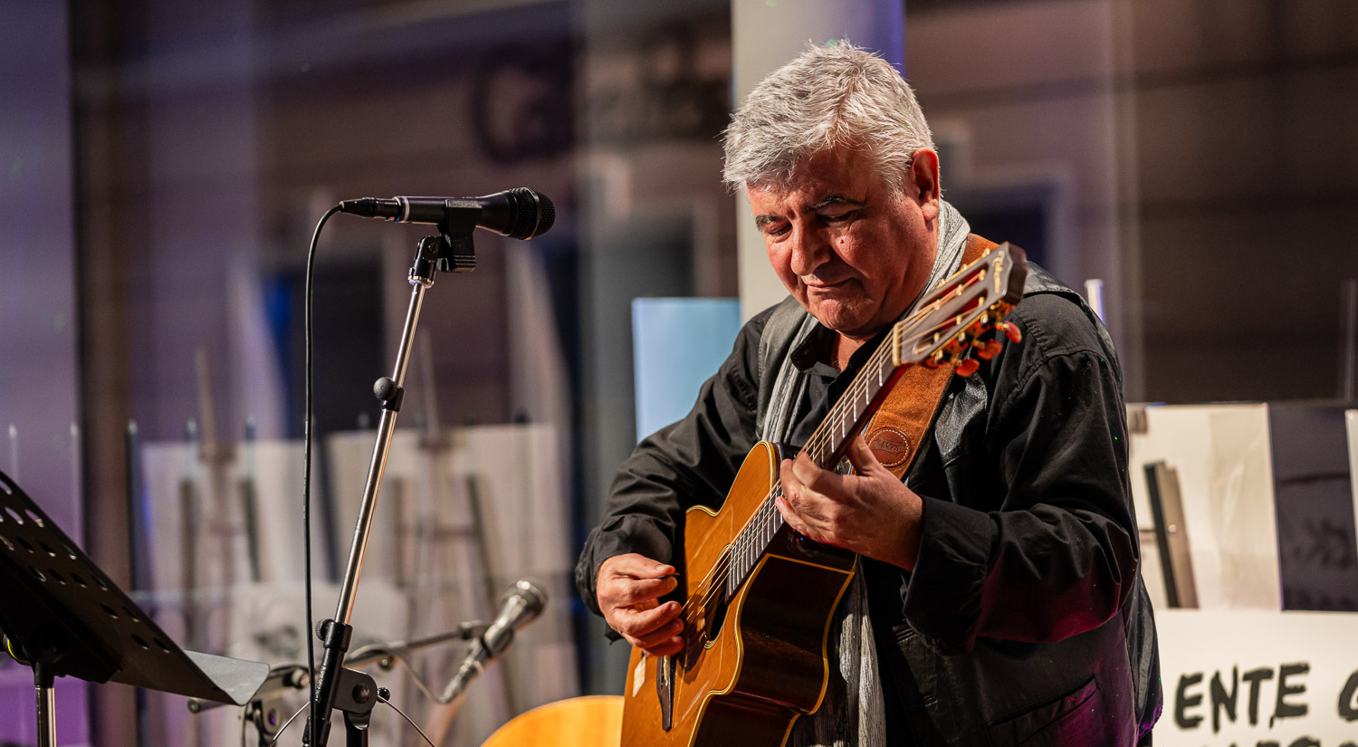 Young ballet dancers in pink tutus performing on a wooden stage under a slatted wooden ceiling