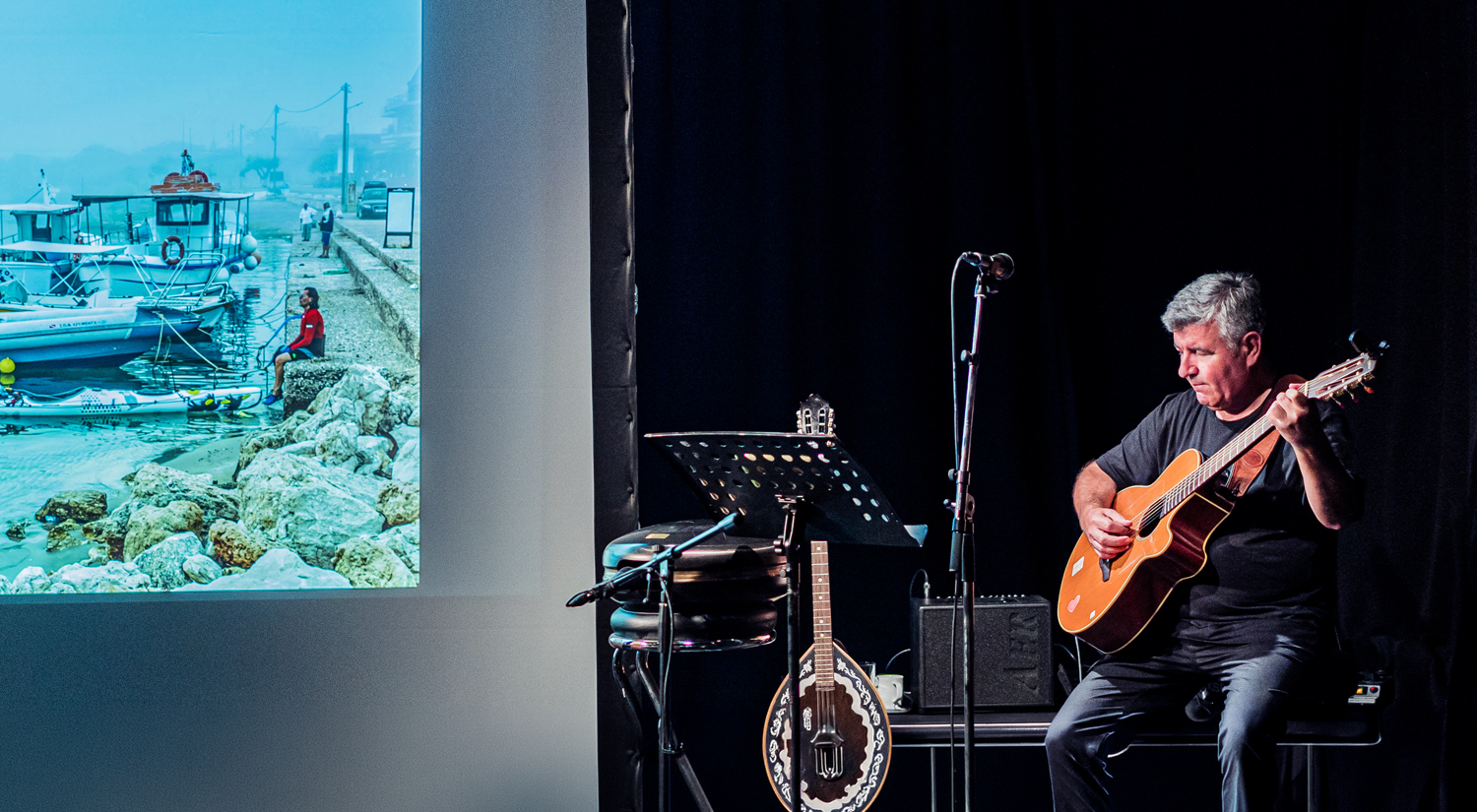 Young ballet dancers in pink tutus performing on a wooden stage under a slatted wooden ceiling